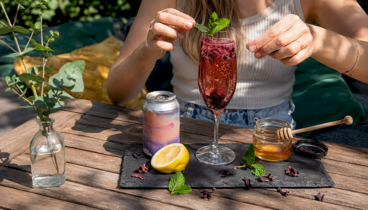 Hands preparing non-alcoholic rose spritz cocktail